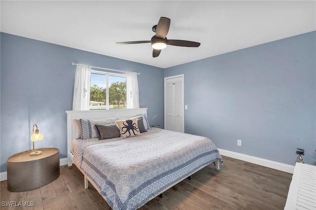 bedroom with dark hardwood / wood-style flooring, a closet, and ceiling fan