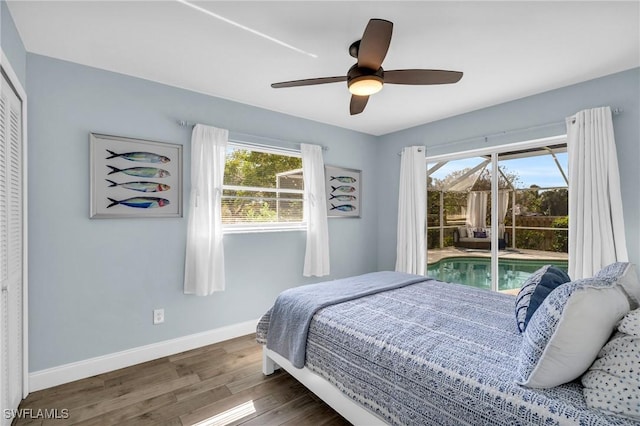 bedroom with dark wood-type flooring, access to outside, ceiling fan, and a closet