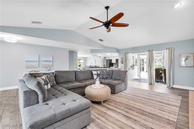 living room with ceiling fan, lofted ceiling, and light hardwood / wood-style flooring