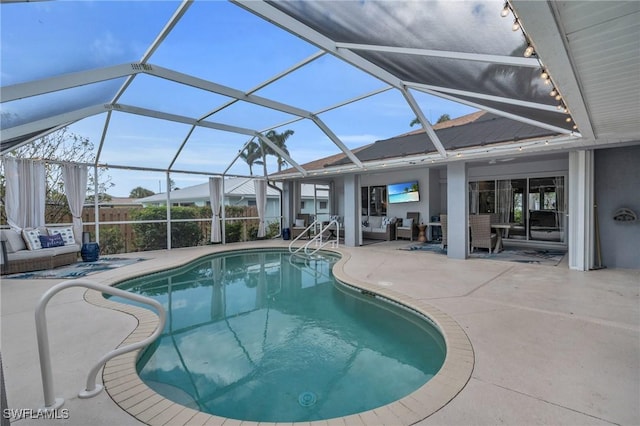 view of pool featuring a patio area, outdoor lounge area, and glass enclosure