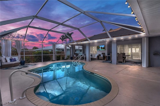 pool at dusk with a patio and a lanai