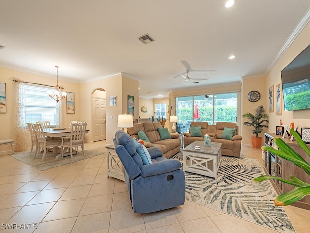 tiled living room featuring ceiling fan with notable chandelier, a wealth of natural light, and ornamental molding