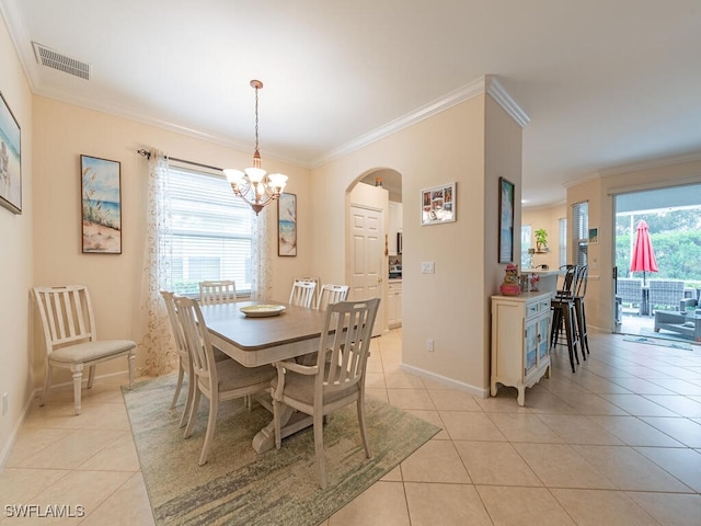 tiled dining area with crown molding and an inviting chandelier