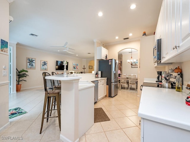 kitchen featuring a breakfast bar area, light tile patterned floors, appliances with stainless steel finishes, kitchen peninsula, and white cabinets