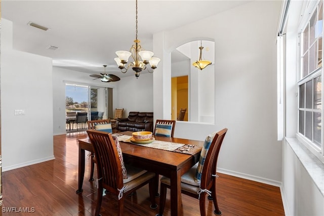 dining area with dark hardwood / wood-style floors and ceiling fan with notable chandelier