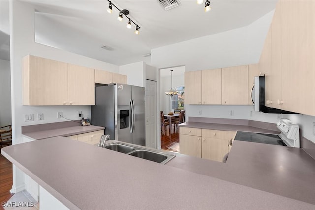 kitchen featuring appliances with stainless steel finishes, kitchen peninsula, and light brown cabinets