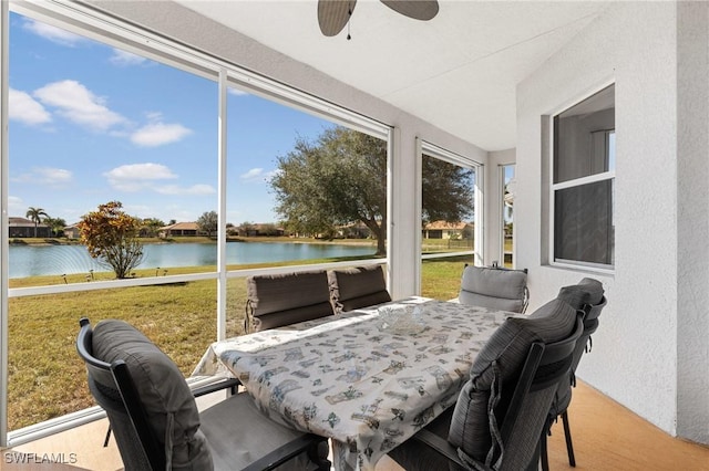 sunroom featuring a water view and ceiling fan