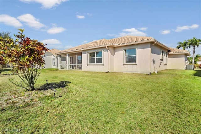 rear view of property with cooling unit and a yard