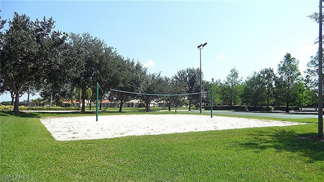 surrounding community featuring a lawn and volleyball court