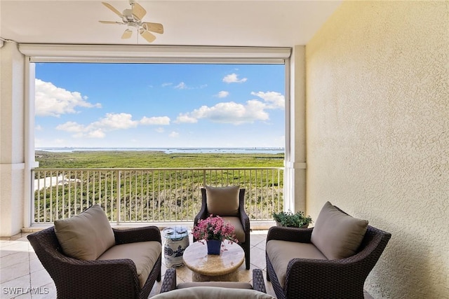 sunroom featuring a water view, a wealth of natural light, and ceiling fan