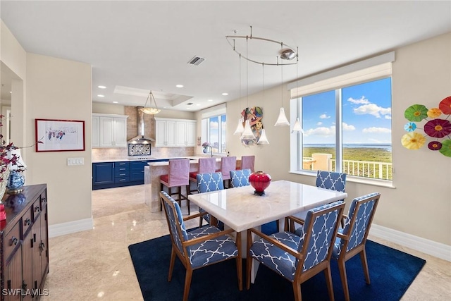 dining area with a raised ceiling