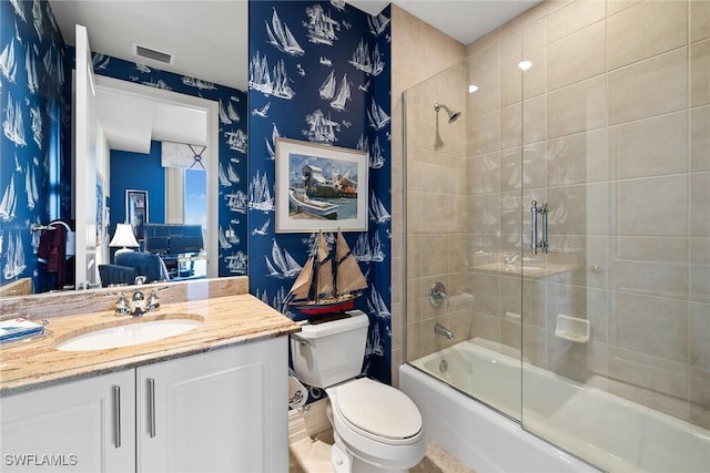 full bathroom featuring vanity, shower / bath combination with glass door, and toilet