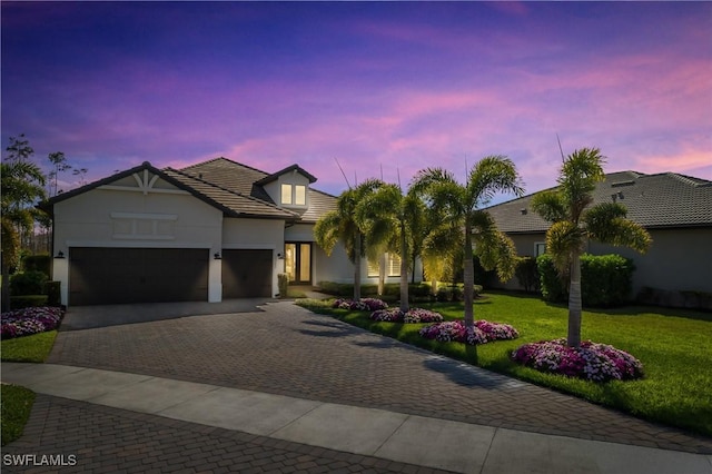 view of front of house with a garage and a yard