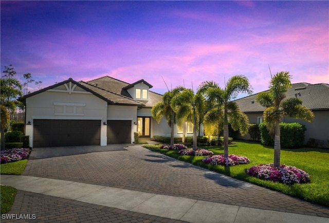 view of front of house with a garage and a lawn