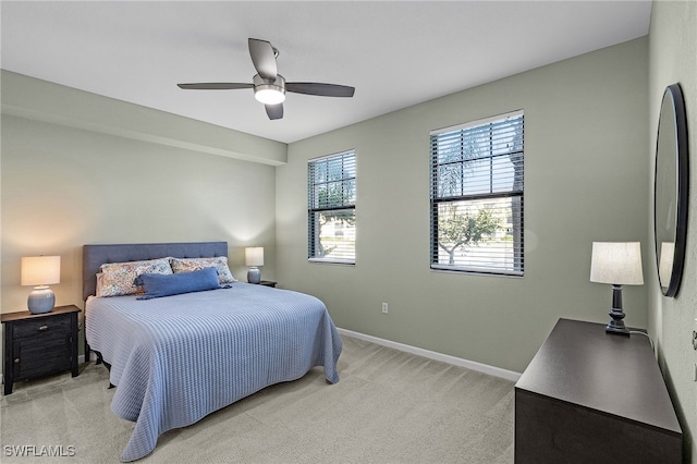 bedroom featuring fridge, light colored carpet, and ceiling fan