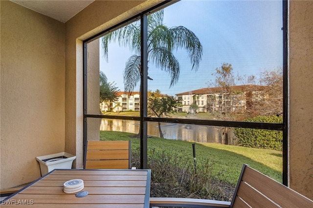 sunroom / solarium featuring a water view