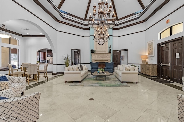 living room with crown molding, a chandelier, and a high ceiling