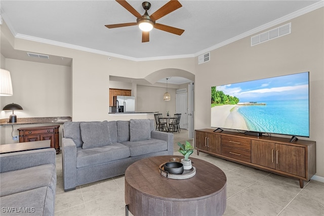 tiled living room with ceiling fan and ornamental molding