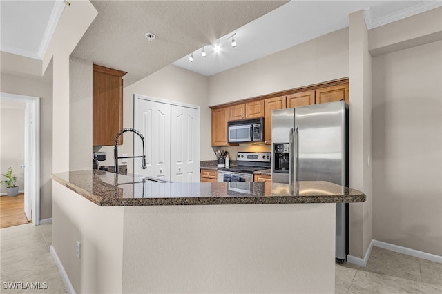 kitchen featuring stainless steel appliances, crown molding, dark stone counters, and kitchen peninsula