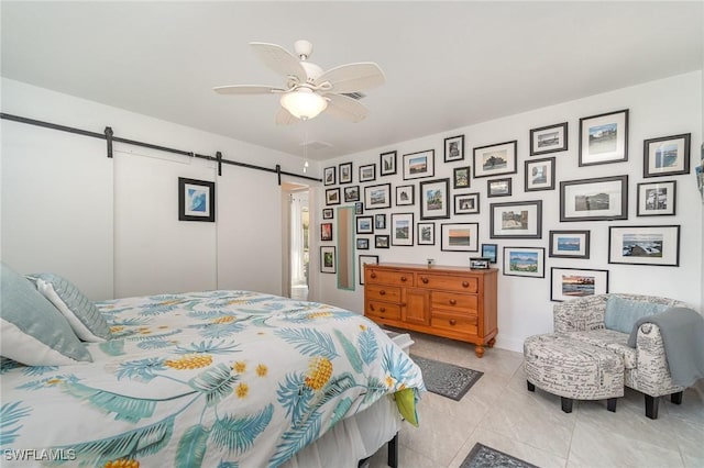 bedroom with a barn door and ceiling fan