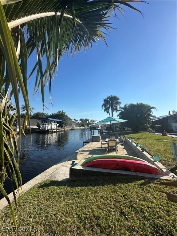 view of dock featuring a water view and a lawn