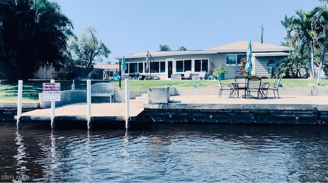 view of dock with a water view and a patio