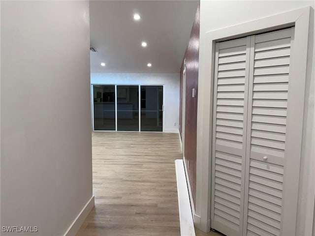 corridor with baseboards, light wood-type flooring, and recessed lighting