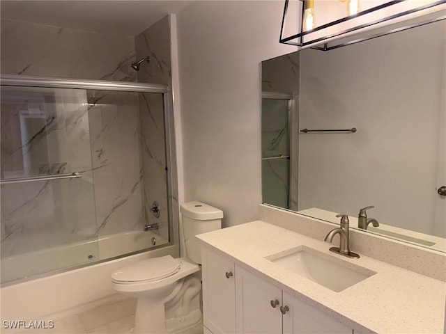 full bathroom featuring enclosed tub / shower combo, vanity, and toilet