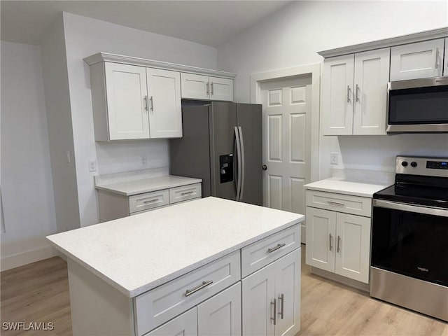 kitchen featuring white cabinets, lofted ceiling, appliances with stainless steel finishes, and light wood-type flooring