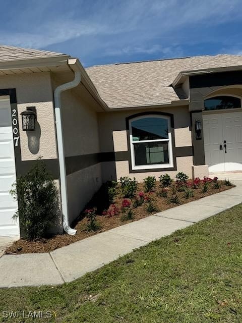 exterior space featuring an attached garage and stucco siding