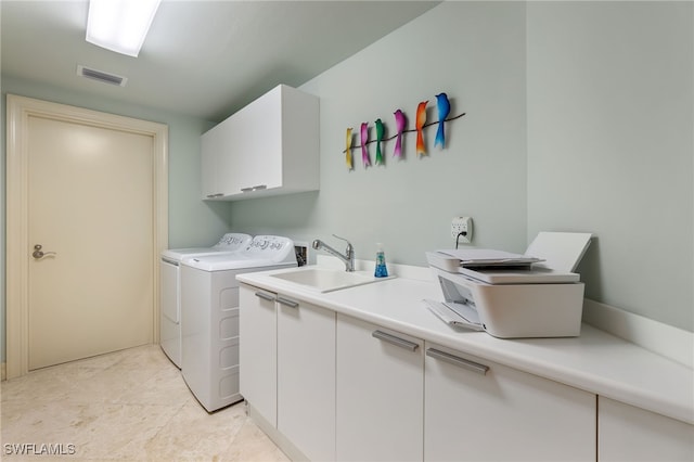 washroom with sink, washer and clothes dryer, and cabinets