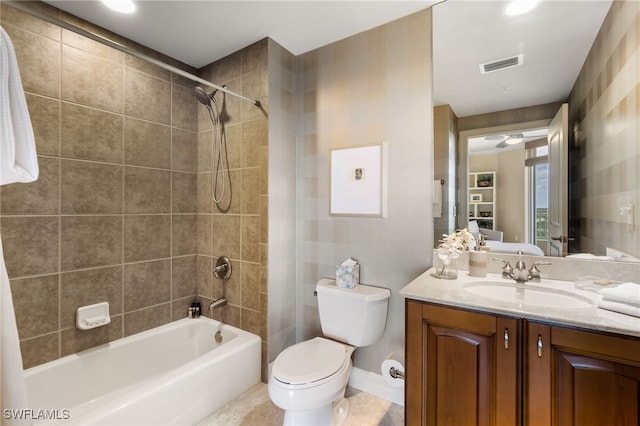 full bathroom featuring vanity, tiled shower / bath combo, and toilet