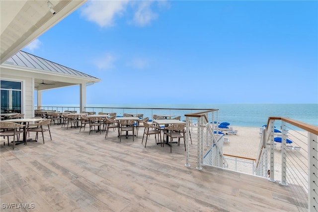 view of patio / terrace with ceiling fan, a beach view, and a water view