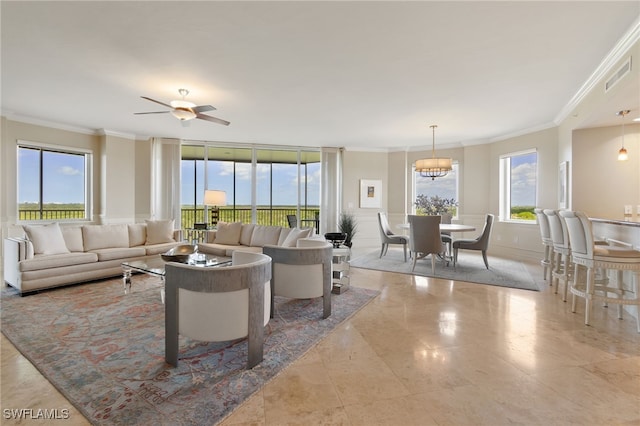 living room featuring ceiling fan with notable chandelier, ornamental molding, and a healthy amount of sunlight