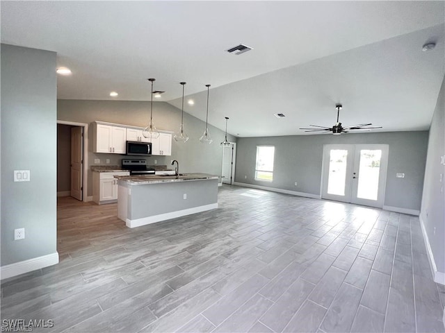 kitchen featuring pendant lighting, white cabinetry, a kitchen island with sink, stainless steel appliances, and vaulted ceiling