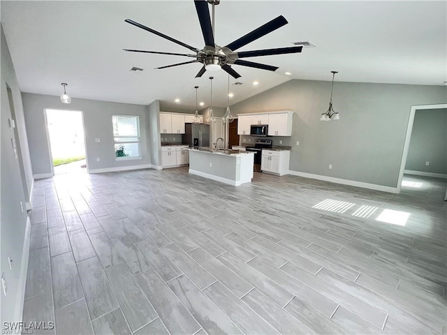 unfurnished living room featuring vaulted ceiling, sink, and ceiling fan