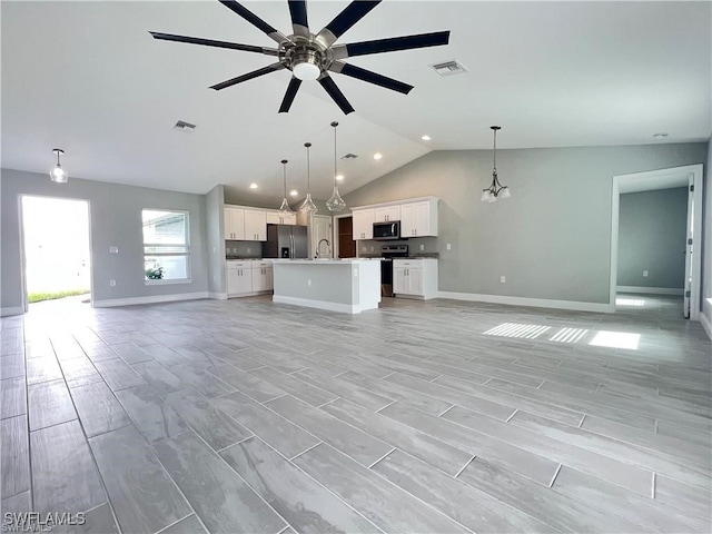 unfurnished living room featuring ceiling fan, sink, and vaulted ceiling