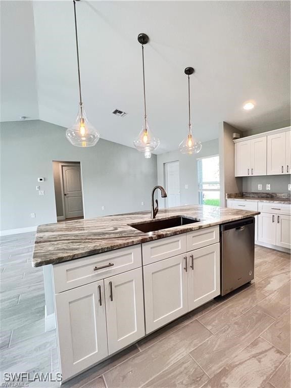 kitchen featuring sink, decorative light fixtures, an island with sink, and dishwasher