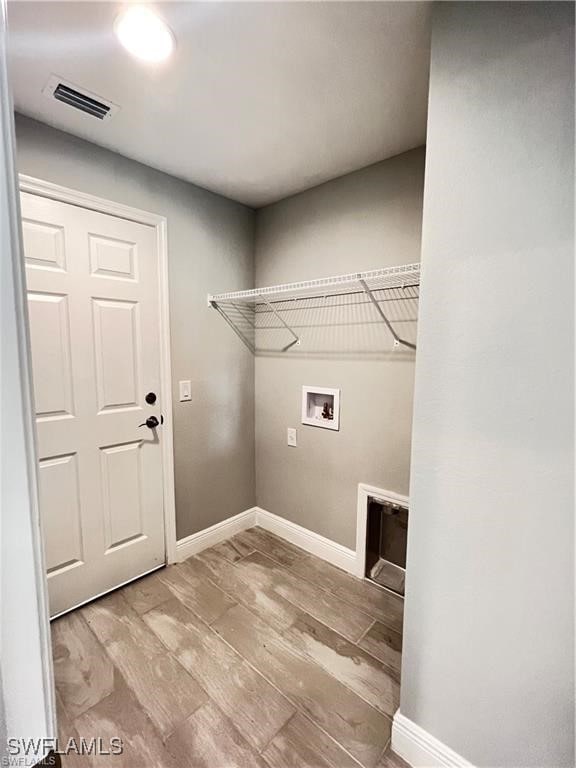 washroom with hookup for a washing machine and light hardwood / wood-style floors