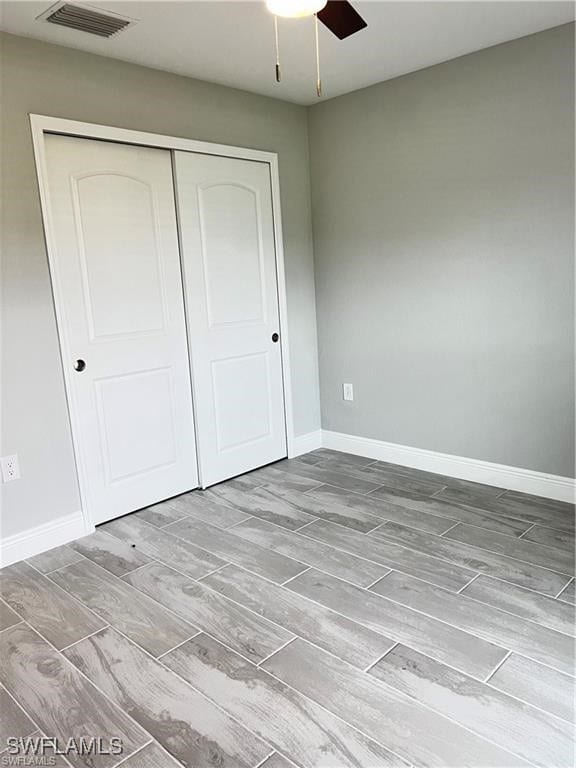 unfurnished bedroom featuring ceiling fan and a closet