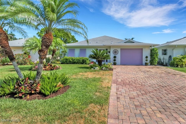 single story home featuring a garage and a front yard