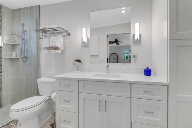 bathroom featuring vanity, ceiling fan, a shower with door, and toilet