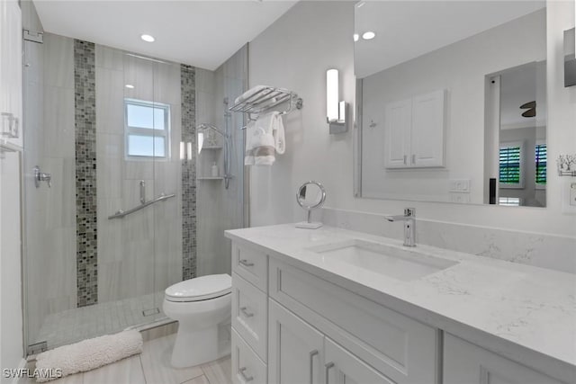 bathroom with vanity, toilet, and a shower with door