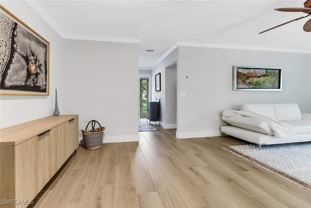 interior space with ceiling fan, ornamental molding, and light wood-type flooring