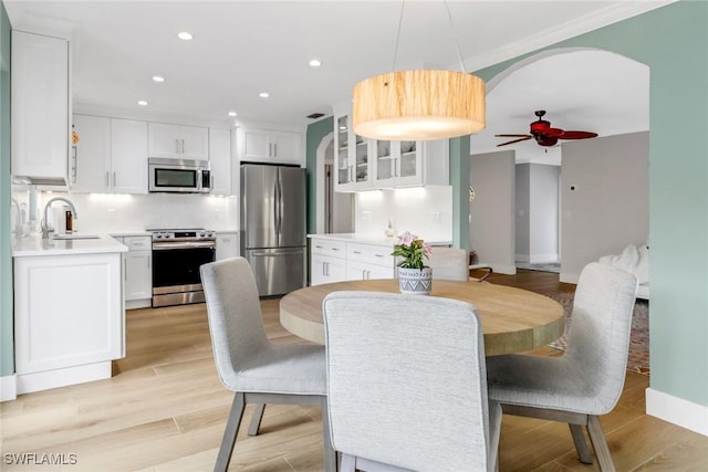 dining area with ceiling fan, sink, and light hardwood / wood-style floors