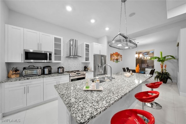 2330 6th Ave NE, Naples, FL 34120 - kitchen with sink, a breakfast bar area, stainless steel appliances, an island with sink, and wall chimney exhaust hood