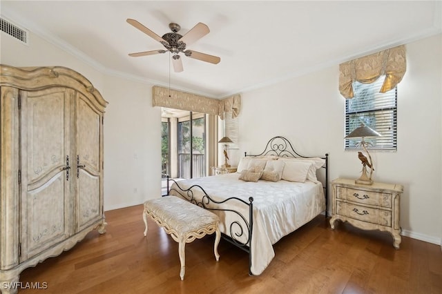 bedroom featuring dark wood-type flooring, access to exterior, and multiple windows