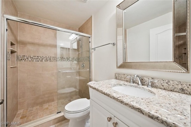 bathroom with vanity, walk in shower, and toilet