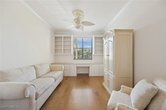 living room featuring crown molding, built in desk, ceiling fan, and light hardwood / wood-style floors