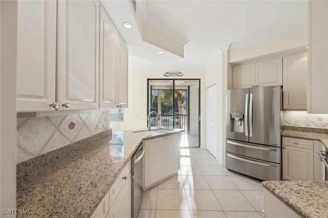 kitchen featuring light stone countertops, ornamental molding, stainless steel appliances, and sink